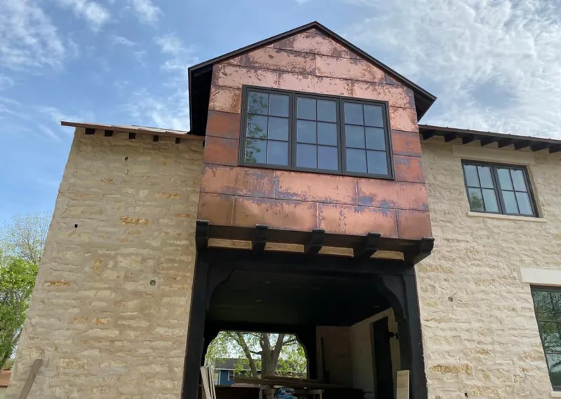 Copper metal panel facade on a stone building for Roof Repair in Highland Lakes