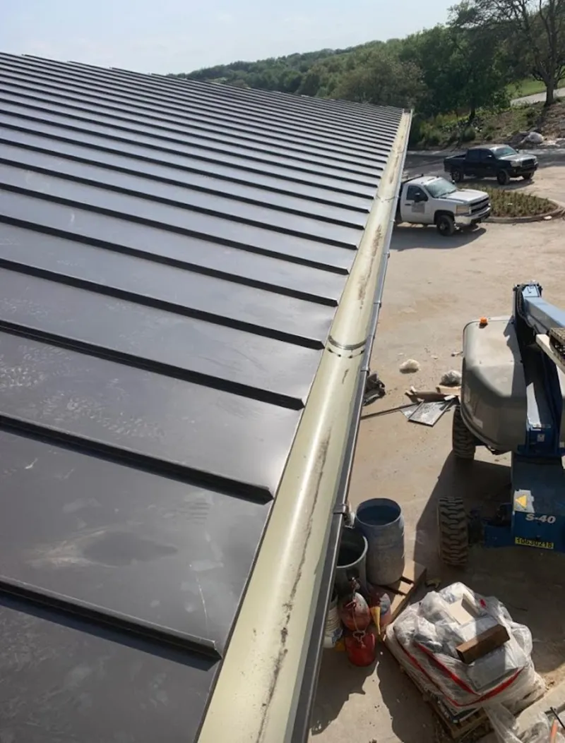 Standing seam panel and gutter detail on a metal roofing jobsite in Highland Lakes